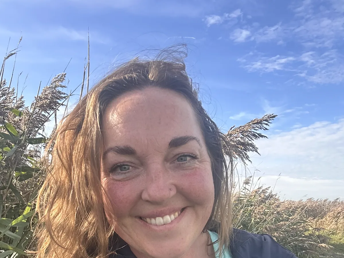 Jennie from Jennie's Positive Paws wearing her branded jacket outdoors in Essex