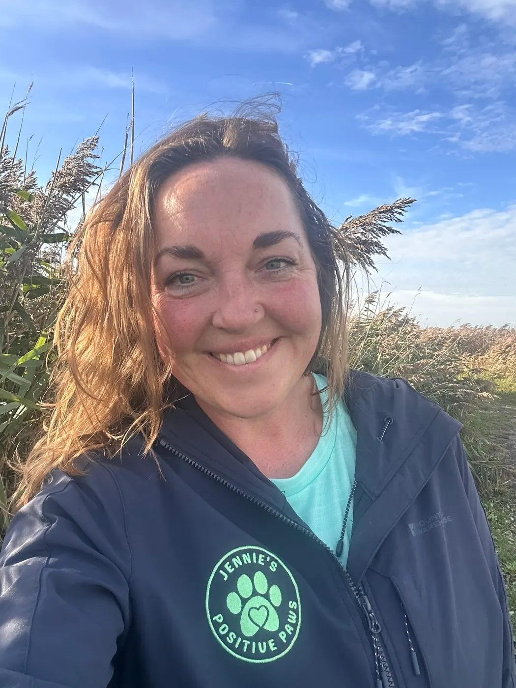 Jennie from Jennie's Positive Paws outdoors in branded clothing